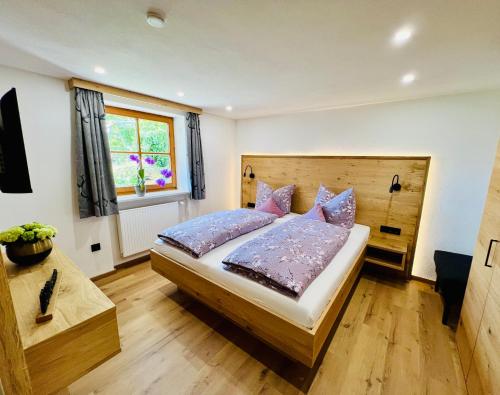 a bedroom with a large bed and a window at Bio-Ferienhof Köpf in Rieden am Forggensee