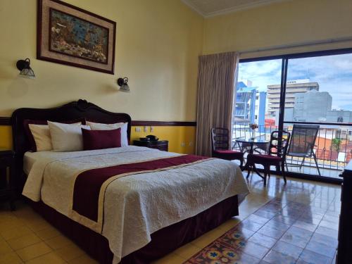 a bedroom with a bed and a view of a city at Hotel Santo Tomas / Historical Property in San José