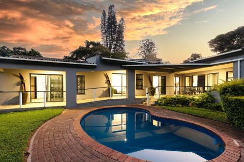 a house with a swimming pool in front of it at 8 On Eagle Bed & Breakfast Room 4 in Port Shepstone