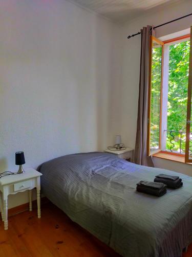 une chambre avec un lit et une fenêtre dans l'établissement Au coeur de Chalabre, bastide médiévale, près du lac de Montbel, à Chalabre