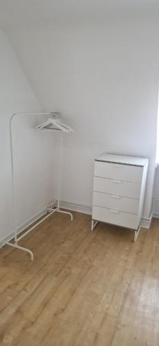 a white dresser in a room with a white wall at Great Stay Botanischer Garten in Kassel