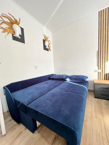 a bedroom with a blue bed in a white room at Maysa Ap in Turda