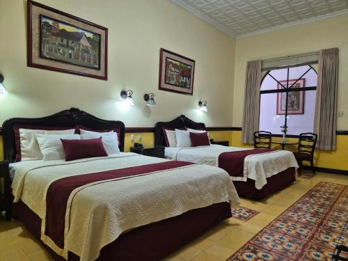 a hotel room with two beds and a window at Hotel Santo Tomas / Historical Property in San José
