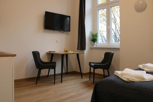 a room with a table and chairs and a tv at RIVER VIEW APARTMENT Wohnen am Fluss in Linz