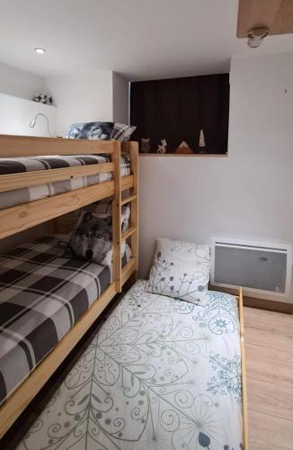 a bedroom with two bunk beds and a flat screen tv at Appartement César de standing plein centre in Cauterets