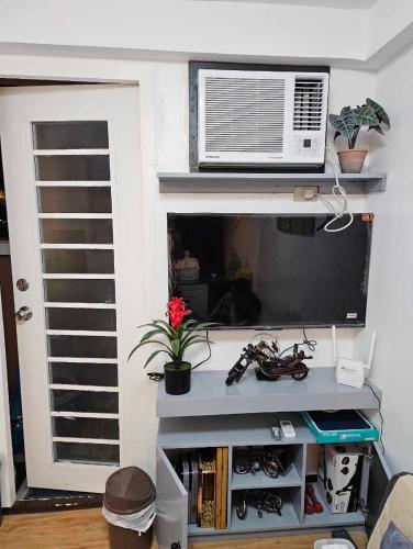 a living room with a flat screen tv and a fan at Your Davao Home, Awaits You at Arezzo Place Davao! in Sasabayou