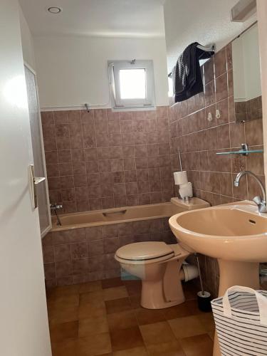 une salle de bain avec toilettes, lavabo et baignoire dans l'établissement La maison des dunes de Kerambigorn, à Fouesnant