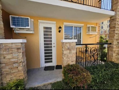 a house with a white door and a balcony at Your Davao Home, Awaits You at Arezzo Place Davao! in Sasabayou