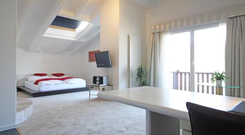 a bedroom with a bed and a table in a room at Seminar- & Erlebnishotel RömerTurm in Filzbach