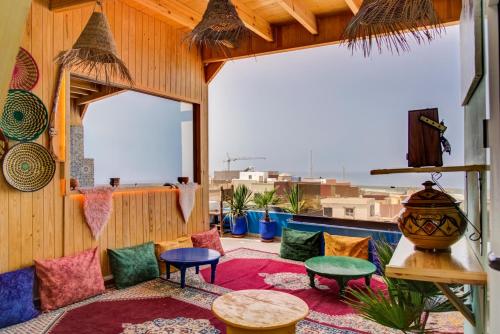 a room with colorful chairs and tables on a balcony at imsouane bleu bay house in Imsouane