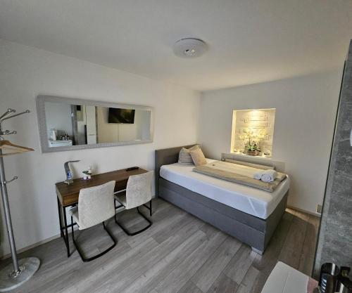 a small room with a bed and a desk and a table at Perfekt suite Sunny room 2 in Dinkelsbühl