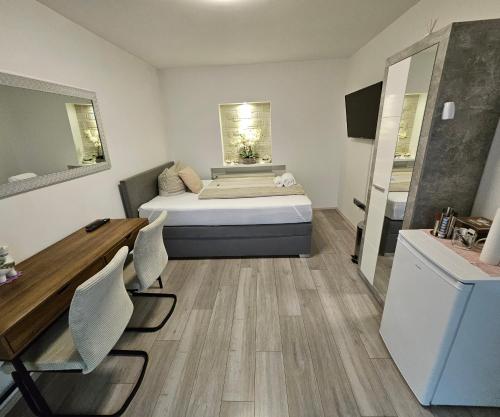 a bedroom with a bed and a desk in it at Perfekt suite Sunny room 2 in Dinkelsbühl