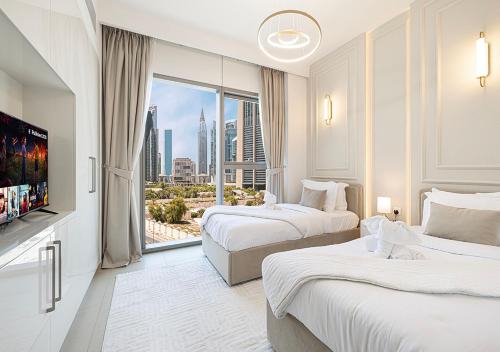 a hotel room with two beds and a large window at Stylish Burj khalifa view 5 Star 4BD Apartment in Downtown with Dubai Mall access - Brand New Apartment in Dubai