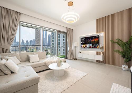 a living room with a couch and a tv at Stylish Burj khalifa view 5 Star 4BD Apartment in Downtown with Dubai Mall access - Brand New Apartment in Dubai