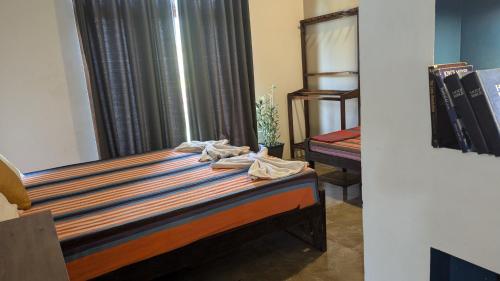 a bedroom with a bed and a window at Aiden Homestay in Pasikuda