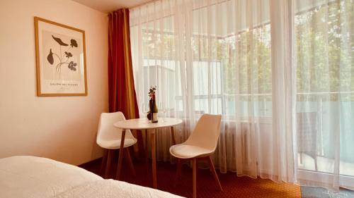 una camera da letto con un letto, un tavolo e una finestra di G&P Housing Apartments mit Küche & Balkon & HighSpeed Internet- Comfort ad Altensteig