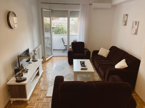 a living room with a couch and a tv at Apartment Troi in Pristina