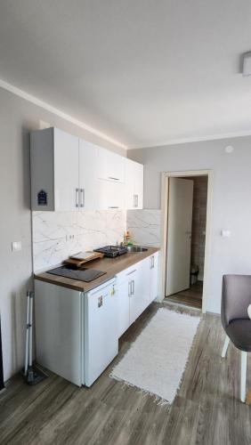 a kitchen with white cabinets and a counter top at Apartmani Đorđević in Soko Banja