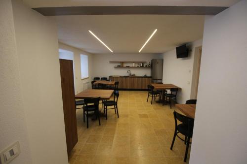a dining room with tables and chairs and a kitchen at Al Vecchio Baito in Rovere Veronese