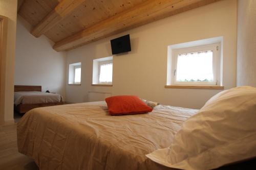 a bedroom with a bed with a red pillow on it at Al Vecchio Baito in Rovere Veronese