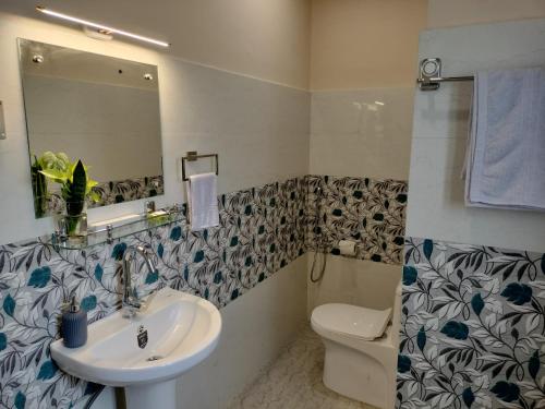 a bathroom with a sink and a toilet and a mirror at Bononi in Jorhāt