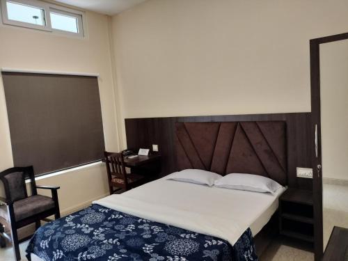 a bedroom with a large bed and a chair at Bononi in Jorhāt