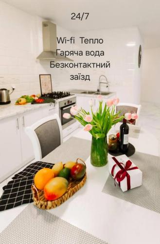 a kitchen with a basket of fruit on a table at Black&White Нова стильна квартира на Київській in Ternopilʼ