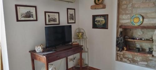 a living room with a television on a wooden table at A casa di Peppino Villa Greco in Tindari