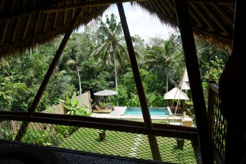 a view from the window of a resort with a swimming pool at Pitu, a Punggul Village Escape in Sangeh