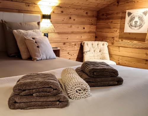 - une chambre avec 2 lits et des serviettes dans l'établissement Chalet Josaly Jacuzzi et Sauna, à Samoëns