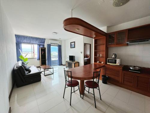a kitchen and living room with a table and chairs at Jade Tower in Chiang Mai