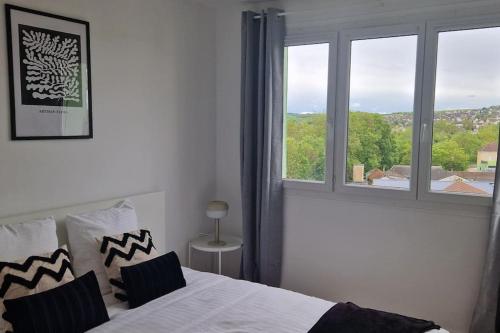 une chambre avec un lit et une grande fenêtre dans l'établissement La Belle Vue d'Auxerre, à Auxerre