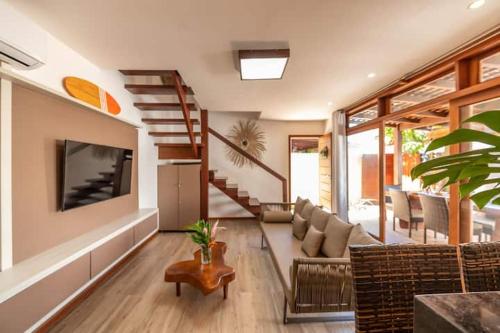 a living room with a couch and a tv at Casa em Barra Grande - Península de Maraú in Barra Grande