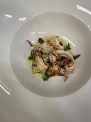 a white plate of food with shrimp on it at Relais Osteria Dell'Orcia in Bagno Vignoni