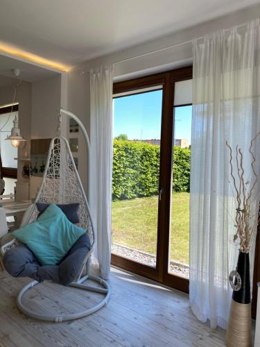 a swinging chair in a room with a large window at Apartament Dani-Apart in Gdańsk