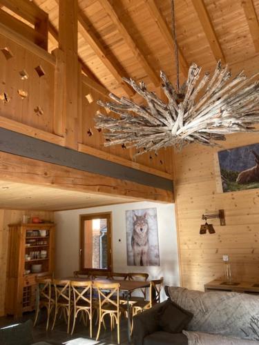 a living room with a chandelier in a cabin at Chalet L'Ourse avec Spa Pralognan-La-Vanoise in Pralognan-la-Vanoise