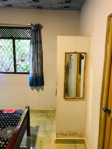 a room with a mirror on the wall and a window at Camelia Holiday Resort in Anuradhapura