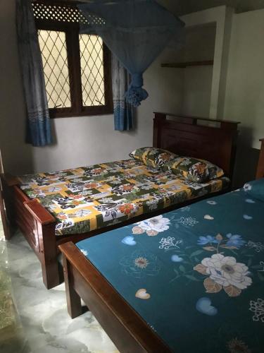 a bedroom with two beds and a window at Camelia Holiday Resort in Anuradhapura