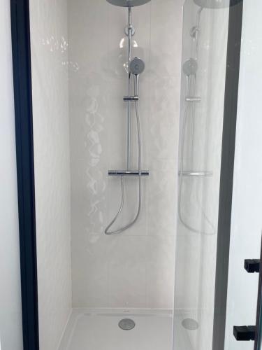 La salle de bains est pourvue d'une douche avec deux flexibles. dans l'établissement Baradozic le petit paradis à Melon, à Porspoder