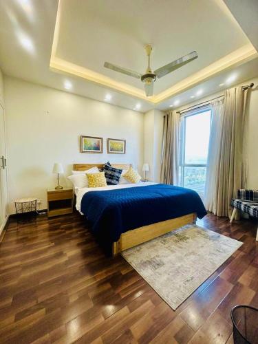 a bedroom with a blue bed and a window at Elysium Luxury 1Bed Apartment! Opposite to Centaurus Mall in Islamabad