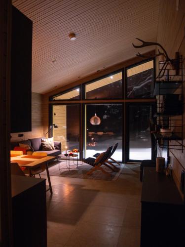 a living room with a couch and a table at Villa Alveus - Nordic design cabin in Ylläs in Kolari
