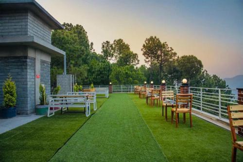 a row of tables and chairs on a balcony at host jatin kasauli crest 7o1827o7o3 in Kasauli