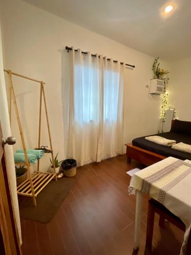 a bedroom with a bed and a room with a swing at StayOver Villa at Travellers Beach Resort in General Luna