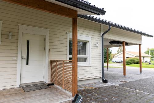 a front porch of a house with a door at Cozy Aurora Chalet with Sauna By BookLapland in Rovaniemi