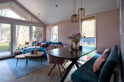 a living room with a couch and a table at Royal Resort Cosy Cabin met Hottub in Haarle