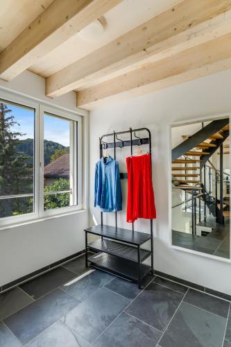 a room with two racks of clothes in a room with windows at Einzigartige Architekten-Wohnung in Winterthur in Brütten