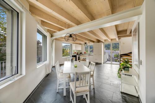 a dining room with a table and chairs and windows at Einzigartige Architekten-Wohnung in Winterthur in Brütten