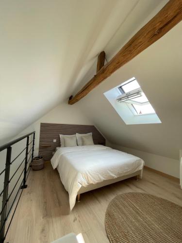 une chambre avec un lit dans un grenier dans l'établissement Duplex au cœur de Châteauroux, à Châteauroux