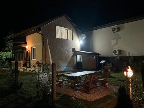 a house with a picnic table in the yard at night at VillaH Weekend House in Visoko