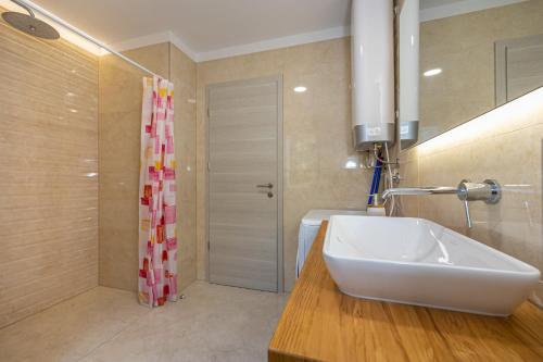 une salle de bain avec un lavabo blanc et une douche dans l'établissement Milu, à Crikvenica
